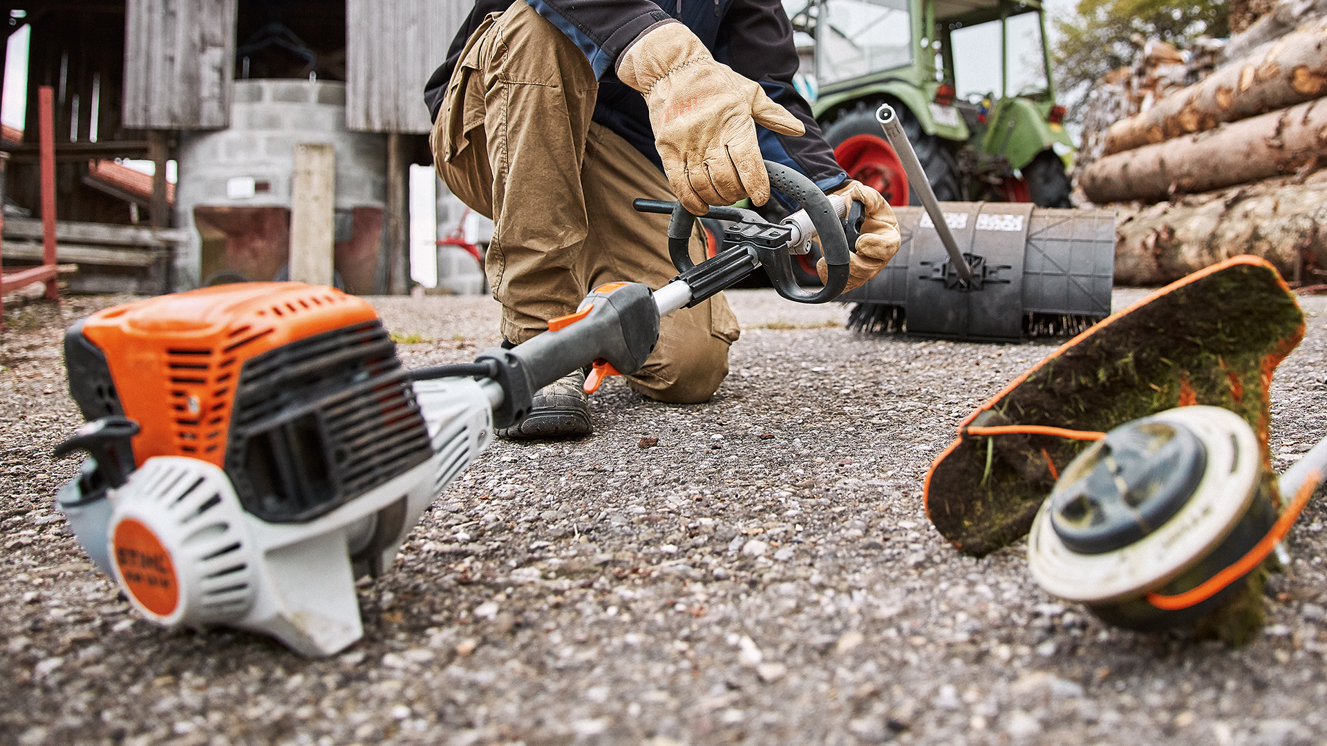 Mann mit STIHL KombiSystem KM 131 R und Anbauwerkzeuge auf einem Hof Hintergrund