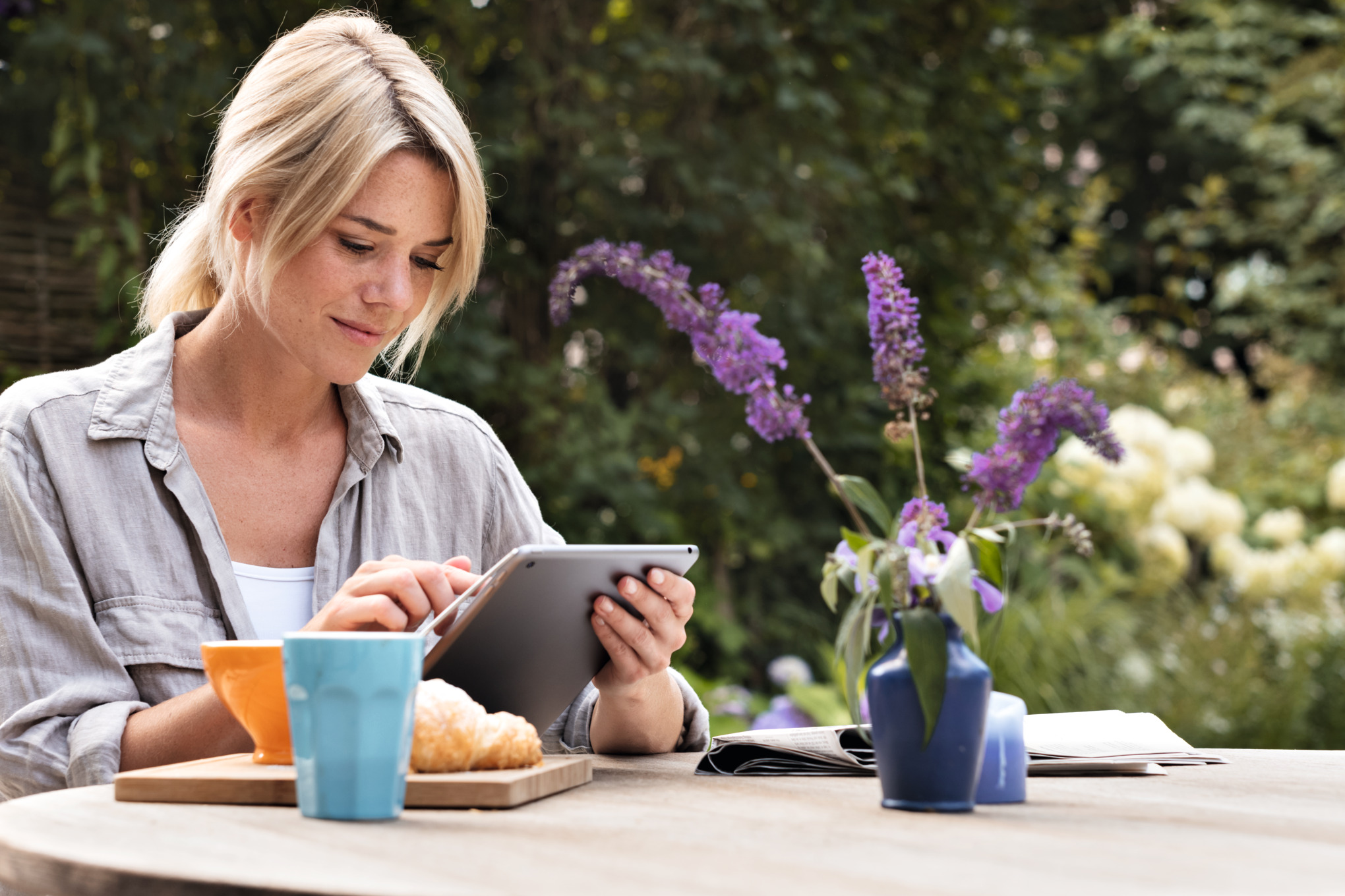 Γυναίκα χρησιμοποιεί την εφαρμογή STIHL iMOW στον κήπο της με το tablet