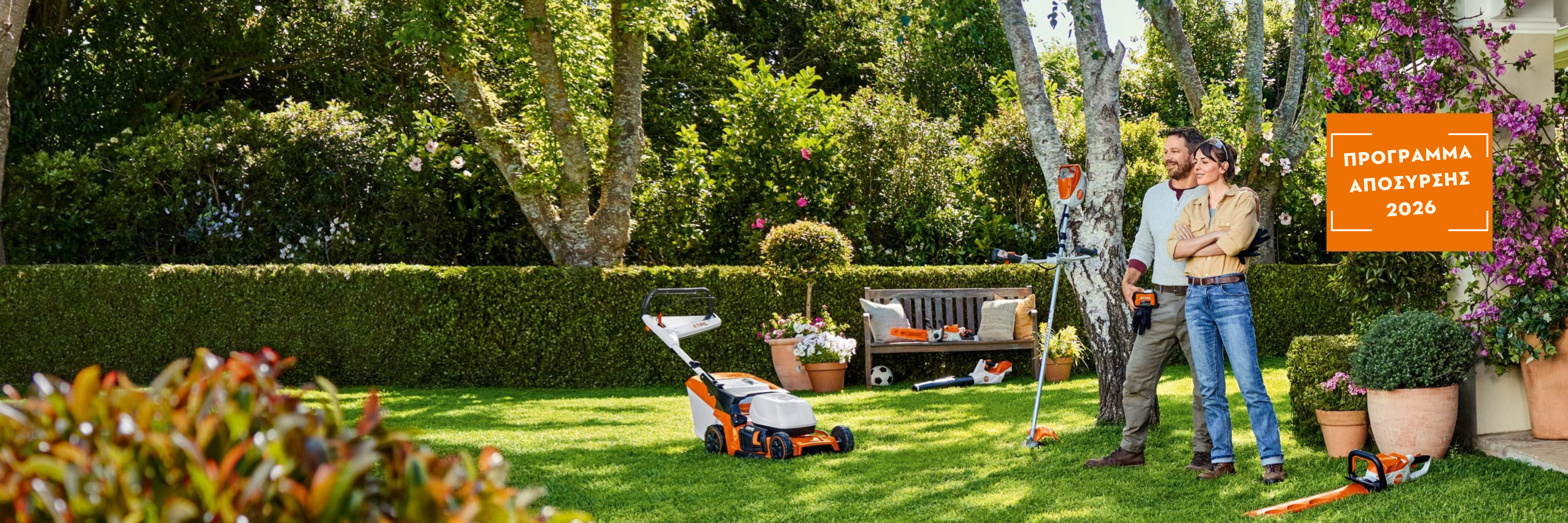 Μία γυναίκα και ένας άνδρας κάθονται στον κήπο δίπλα στα μηχανήματα STIHL